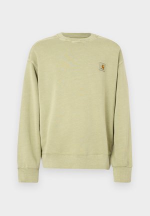 Lys grønn genser med klassisk rund hals, ribbestrikkede mansjetter og en liten rektangulær logopatch på venstre bryst. Mykt, teksturert stoff.