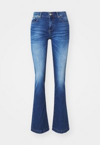 Jean évasé en denim bleu délavé moyen, avec une braguette zippée, cinq poches et un léger effet délavé vers l'ourlet. Longueur normale.