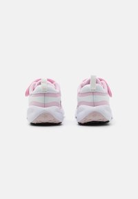 Zapatillas deportivas con una combinación de colores rosa y blanco, que presentan una parte superior de malla, suela de goma y una lengüeta en la parte trasera para facilitar su uso.