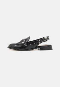Black leather slingback shoe with a low heel, adorned with silver studs and a decorative strap across the toe. Smooth texture and glossy finish.