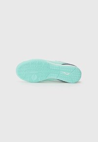 Sole di una sneaker, caratterizzata da un materiale in gomma verde menta testurizzato con un motivo a zigzag e un logo bianco vicino al tallone.