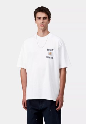 Maglietta in cotone bianco con vestibilità rilassata, con la scritta "Carhartt University" e il logo in nero e arancione sul petto sinistro. Collana con catena d'argento.