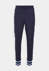 Marinblå sweatpants med dragsko i midjan, sidofickor och blårandiga mudd. Tillverkade av mjukt material med en skräddarsydd passform och subtil textur.