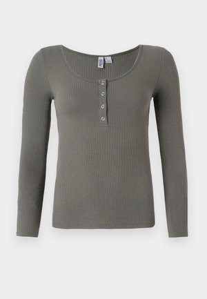Maglietta a maniche lunghe in un verde tenue, con scollatura a barca e cinque bottoni a pressione metallici sul davanti.