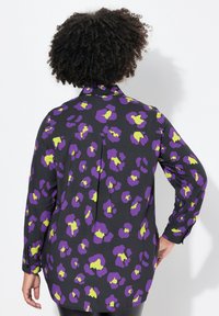 Sort skjorte med lilla og limegrøn leopardmønster, letvægtsstof, lange ærmer og plissé detalje bagpå.