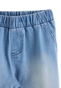 Hellblaue Denim-Shorts mit elastischem Bund, ausgestattet mit Seitentaschen und sichtbaren Nahtdetails. Weiche Textur und lässiges Design.