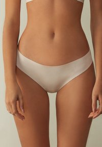 Beige hipsterondergoed met een soepele textuur en een lage snit. Subtiele naden en geen zichtbare taillebandaccenten.