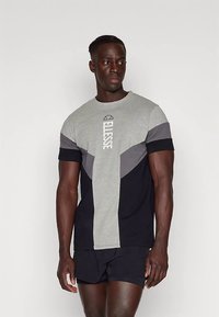 Pilkos ir tamsiai mėlynos spalvų trumpomis rankovėmis marškinėliai su „Ellesse" logotipu, apvalia iškirpte ir kontrastingais geometriniais raštais.