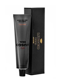 Schwarze Tube mit Musgo Real Rasiercreme mit matter Oberfläche, mit geprägtem Text und einem klassischen Logo, aufrecht neben einer schwarzen Box platziert.