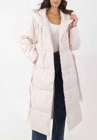 Abrigo largo tipo acolchado de color rosa claro con capucha, cierre de botones y bolsillos laterales. Presenta un diseño acolchado con una textura suave.