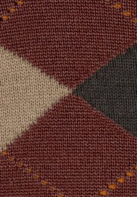 Textil que muestra un patrón de punto con formas de diamante en burdeos, beige, verde oscuro y marrón claro, acentuado por detalles de costura en naranja.