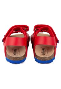 Sandales en cuir rouge avec des sangles réglables, semelles en liège et semelles extérieures en caoutchouc bleu. Présentent des talons fermés et un design arrondi.