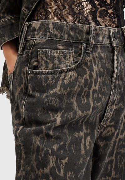 Jeans en denim noir taille haute avec un imprimé léopard beige, dotés de poches et de détails en métal. Tissu texturé avec une légère finition effilochée.