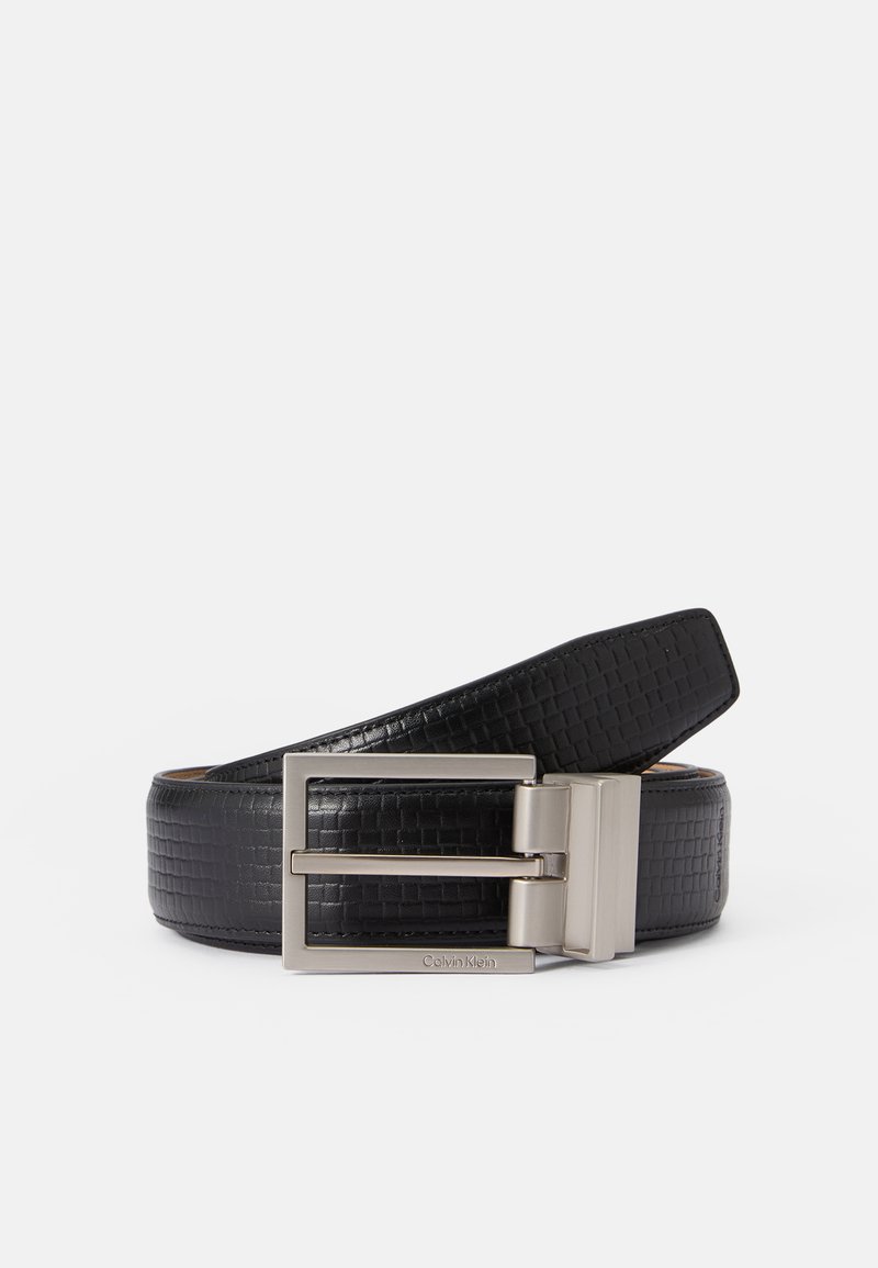 Ceinture en cuir noir avec une surface texturée et une boucle rectangulaire en argent. Présente une finition lisse et des coutures détaillées le long des bords.