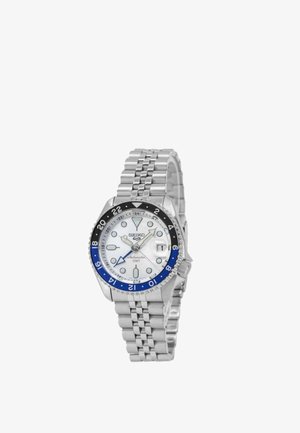 Orologio da polso Seiko argentato con quadrante bianco, lunetta 24 ore nera e blu, finestra della data e cinturino in metallo a maglie.