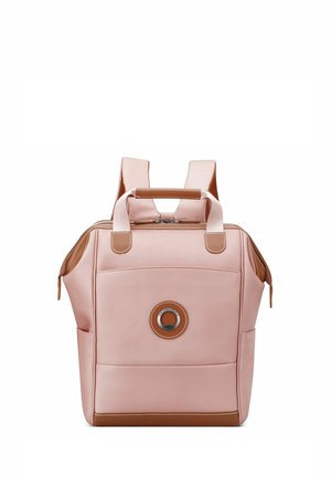 Sac à dos rose en matériau synthétique avec des accents marron, doté de deux bretelles, d'une poignée supérieure et d'une fermeture éclair. Détail d'un logo circulaire.