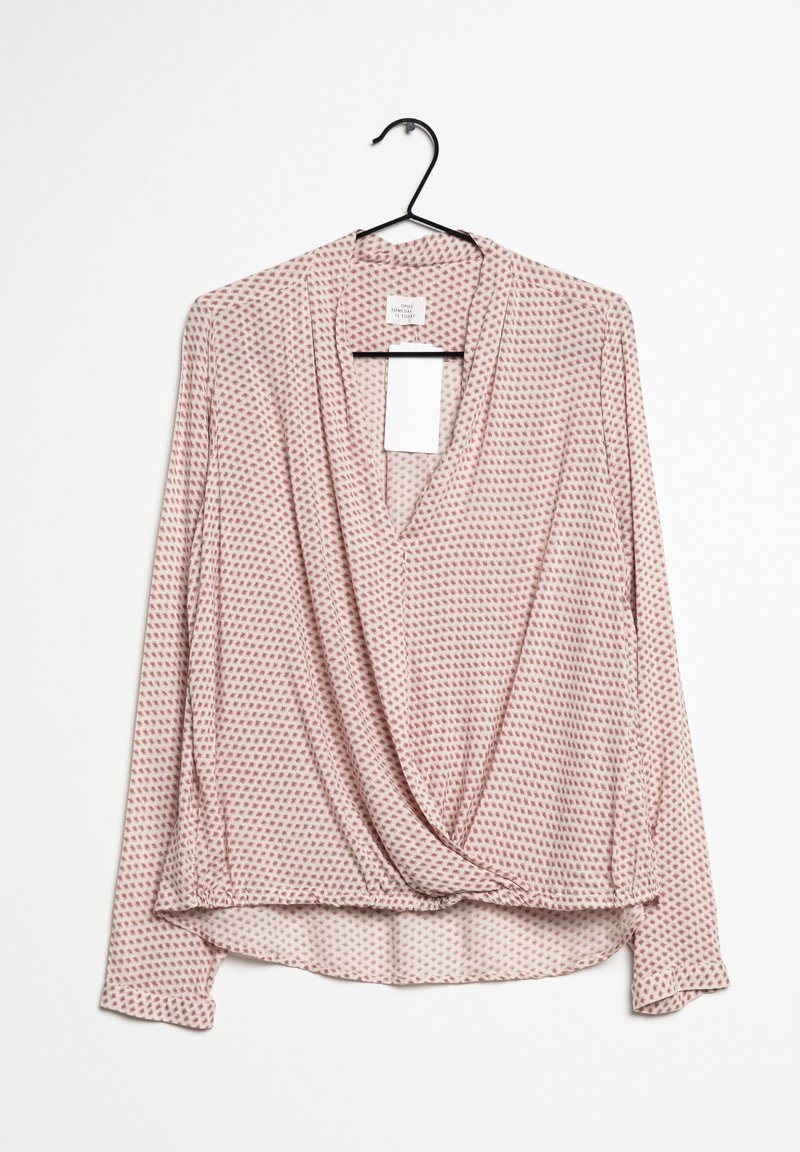 Blusa rosa a maniche lunghe con design avvolgente, caratterizzata da piccoli motivi geometrici rossi, scollatura a V e un tessuto morbido e leggero.