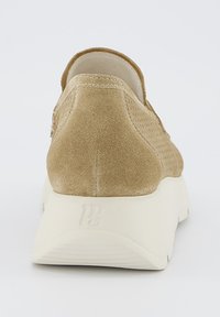 Sneaker in suede beige con tomaia testurizzata, punta arrotondata e suola in gomma bianca. Presenta un dettaglio del logo sul tallone e linee pulite.