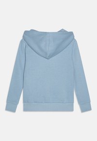 Felpa leggera blu chiaro con tasca a marsupio, polsini e orlo a coste, e cappuccio con coulisse. Tessuto liscio con una finitura di colore uniforme.