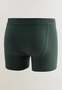 Boxers hommes vert foncé avec une ceinture élastique marquée « NEXT », vus de dos sur un fond uni.