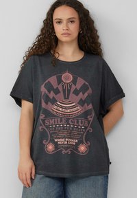 Diepgrijze oversized t-shirt met korte mouwen; heeft een roze grafische print met tekst en geometrische ontwerpen, ronde hals en een relaxte pasvorm.