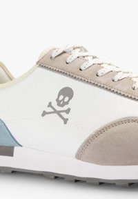 Sportschuh mit einem Obermaterial aus Weiß und Grau, Wildlederakzenten, blauen Details und einer Totenkopf- und Kreuzknochen-Grafik an der Seite. Standard-Schnürung.