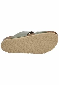Green synthetic slide sandal featuring a cork midsole and textured rubber outsole with a honeycomb pattern, angled view from below.