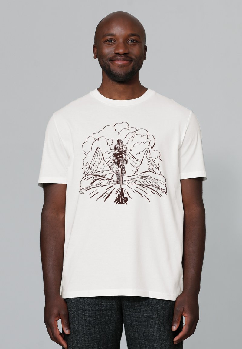Witte katoenen t-shirt met een bruine grafische illustratie van een figuur die naar bergen en wolken loopt, korte mouwen, ronde hals.