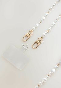 Curea din perle albe cu accesorii aurii și un suport pentru card transparent. Prezintă perle netede și cu forme neregulate, sporind textura și eleganța.