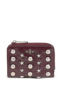 Portefeuille en cuir bourgogne avec quincaillerie en argent, orné de clous ronds et d'accents en forme d'étoile. Fermeture à zip en haut, forme rectangulaire compacte.