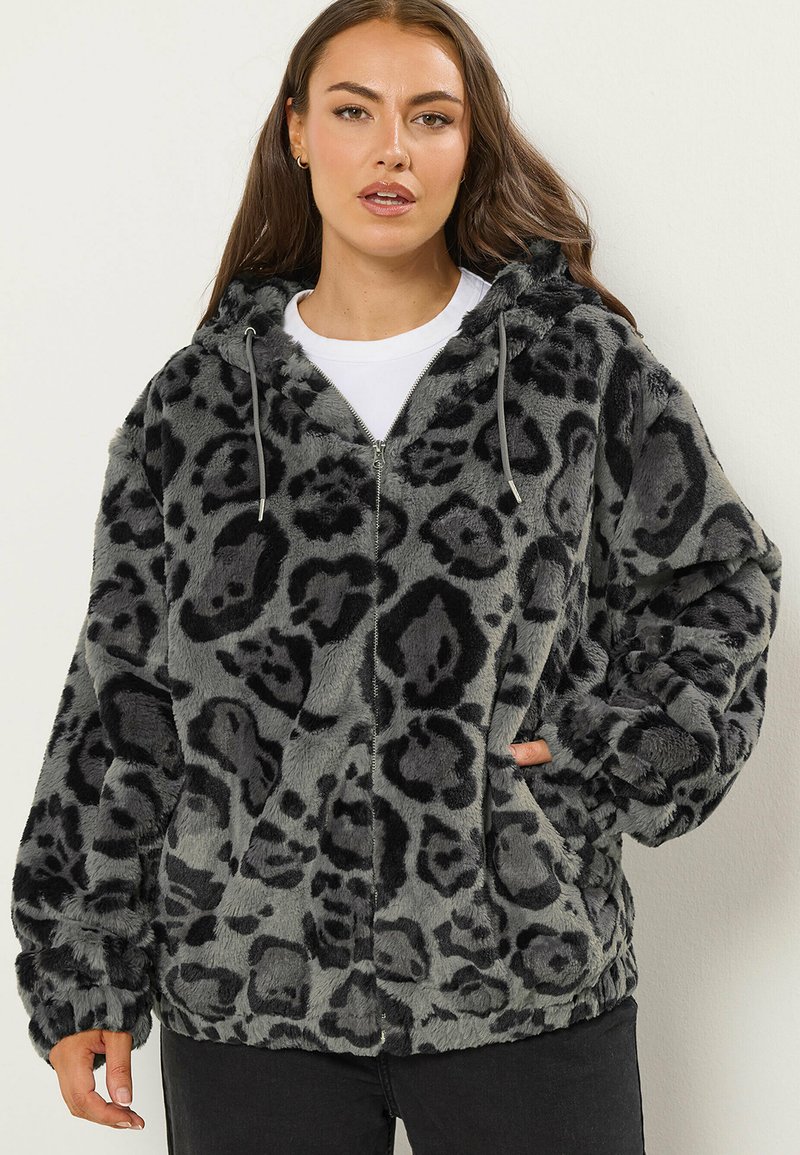 Hoodie en fausse fourrure grise avec imprimé léopard noir, fermeture éclair devant, capuche avec cordon de serrage ajustable et poignets côtelés. Texture douce et coupe surdimensionnée.