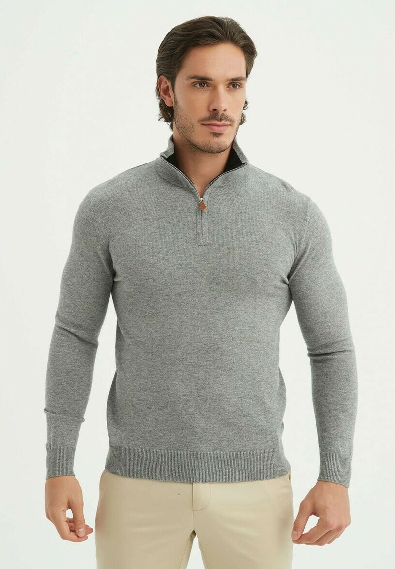 Sweatshirt zippé gris à manches longues, en matériau doux. Doté d'un col montant et de bords côtes aux poignets et à l'ourlet.
