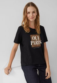T-shirt noir à manches courtes avec un panneau en imprimé léopard et le texte "OUI PARIS" en blanc, fabriqué en coton doux.
