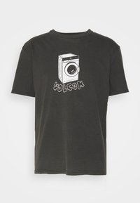 T-shirt in cotone nero con una grafica frontale di una lavatrice e il testo "VOLCOM" in un font cartoon. Girocollo.