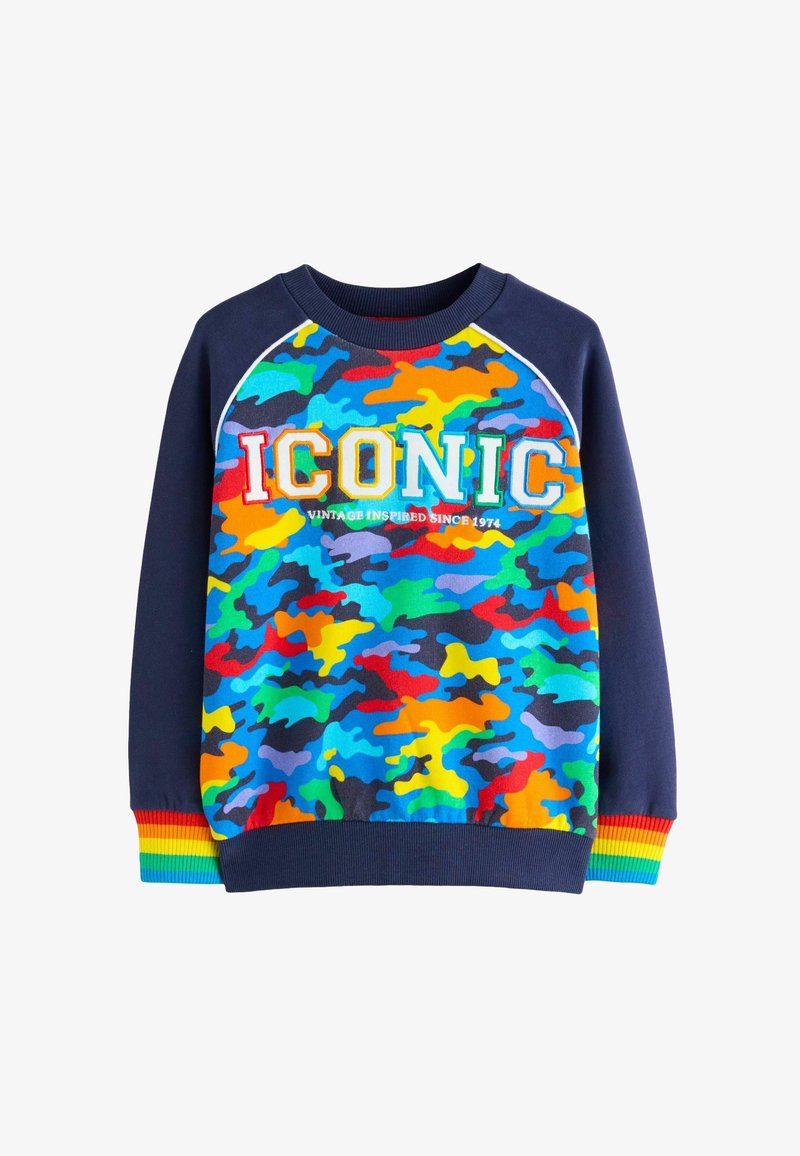 Värviline kamuflaažimustriga sviiter sinistes, rohelistes, kollastes ja punastes toonides. Omab ümarat kaelust, soonikkoes mansette ning esifooril teksti "IKONAALNE".