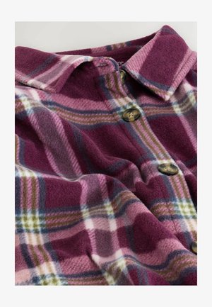 Fleece-Karobluse in den Farben Lila, Pink und Grün mit einem Kragen und zwei braunen Knöpfen. Weicher Stoff mit einem karierten Muster.
