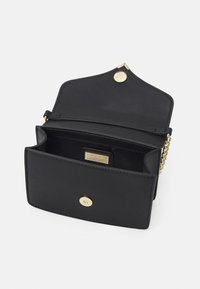 Borsa a tracolla in pelle nera con hardware color oro, caratterizzata da una chiusura a patta, tasca interna e una tracolla a catena. Texture liscia e forma strutturata.