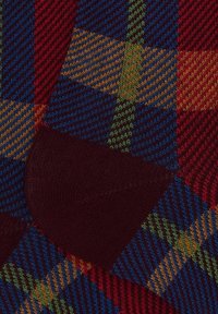 Calzino multicolore con motivo tartan nei colori rosso, blu, verde e giallo; texture a costine con punta bordeaux a contrasto.