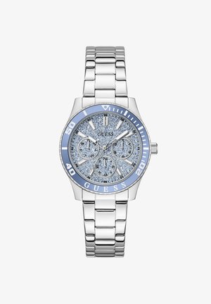 Ασημένιο μεταλλικό ρολόι χειρός με καντράν μπλε με γκλίτερ, τρεις υποκαντράν, φωσφορίζοντες δείκτες ώρας και γαλάζιο στεφάνι με αριθμούς και λογότυπο GUESS.