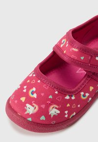 Pink fabric shoe with unicorn and heart patterns, featuring a Velcro strap, cushioned insole, and a textured rubber sole.