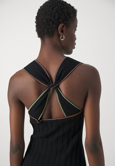 Robe noire à rayures avec un design unique sur le dos croisé, agrémentée de détails colorés. La texture est lisse avec une silhouette ajustée.