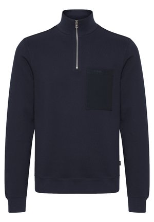 Námořnická mikina s vysokým límcem, zipovým zapínáním a texturovanou náprsní kapsou. Obsahuje žebrované manžety a lem, vyrobená z měkké bavlny.