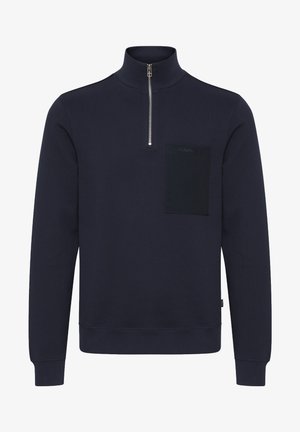 Granatowy sweatshirt z wysokim kołnierzem, zamek błyskawiczny i teksturowana kieszeń na patch. Posiada ściągacze przy mankietach i u dołu, wykonany z miękkiego materiału bawełnianego.