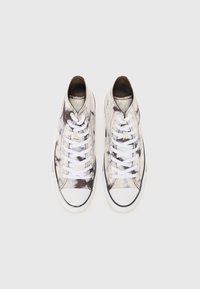 Baskets montantes avec un motif tie-dye en blanc et gris, lacets blancs détaillés, semelle en caoutchouc noire et bout rond.
