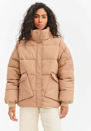 Kurtka puchowa w jasnobrązowym kolorze z wysokim kołnierzem, pikowaną teksturą, zamkiem błyskawicznym z przodu i dwoma dużymi bocznymi kieszeniami.