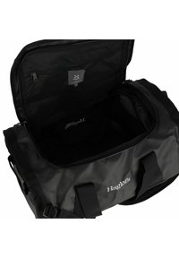 Zwarte sporttas met een ritsopening aan de bovenkant, brede opening en binnenzakken. Gemaakt van duurzame materialen, met stevige handgrepen en logo-ontwerp.