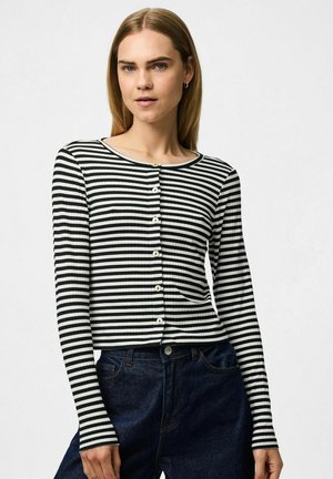 Gestreepte lange mouw top in zwart en wit, met knopen aan de voorkant, ronde halslijn en geribbelde structuur. Gecombineerd met donkere denim.