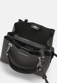 Sac à main en cuir texturé noir avec une poche intérieure zippée, matériel en argent et une bandoulière amovible. Présente un fermoir magnétique.