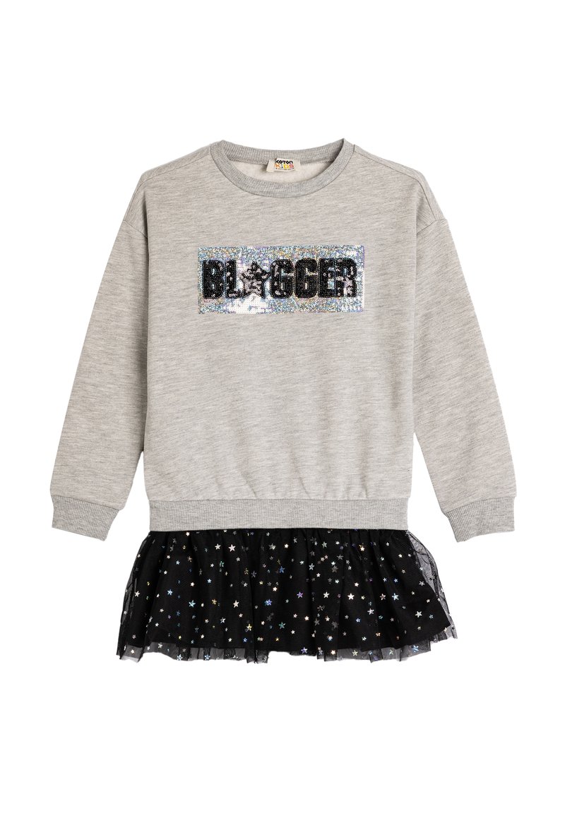 Felpa di cotone grigia con un patch in paillettes nere con la scritta "BLOGGER". Presenta una gonna di tulle nera con ruffles decorata con motivi a stella metallici.