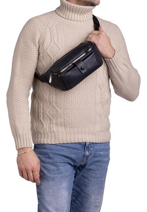 Borsa a vita in pelle blu navy con chiusura zip, patta frontale con bottone e tracolla regolabile indossata a tracolla. Dettaglio in superficie testurizzata.